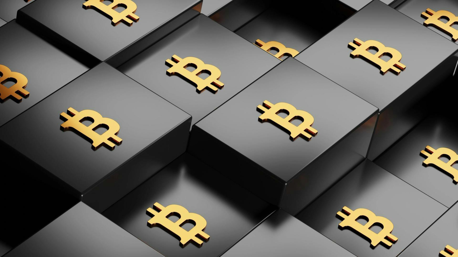 Bitcoin logos on a pile of black boxes.